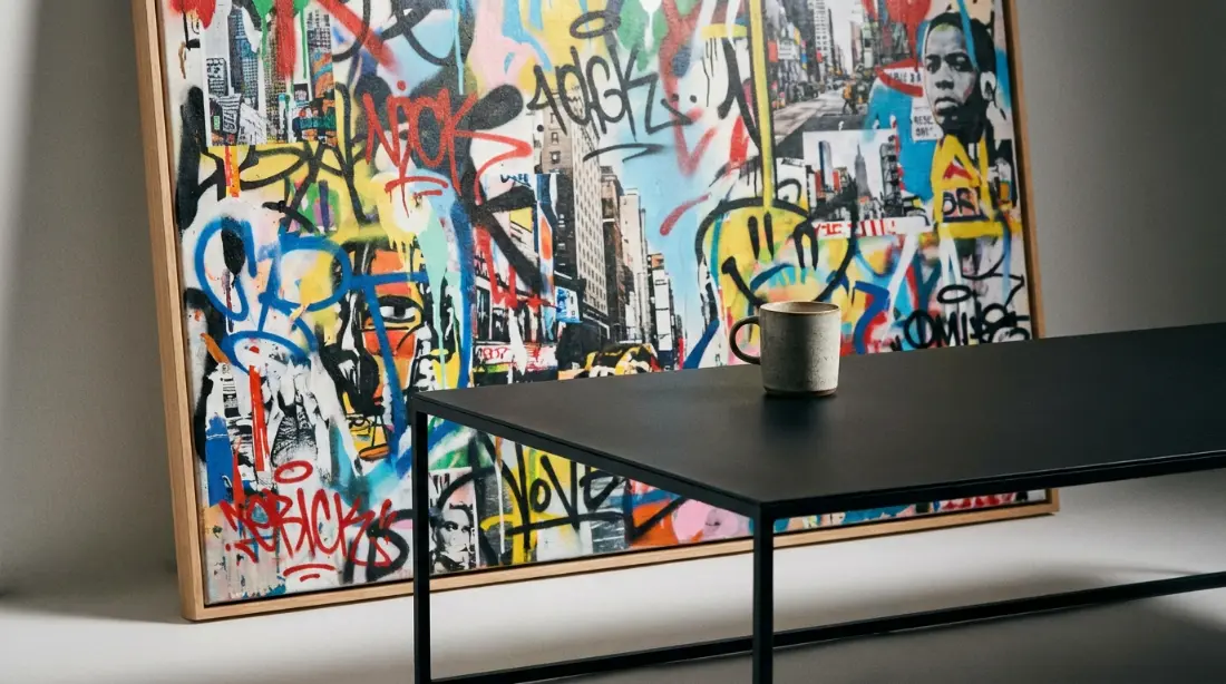 Comment intégrer le style Street Art dans un salon moderne ? tableau street art art urbain à côté d'une table en métal noir mat salon industriel contemporain